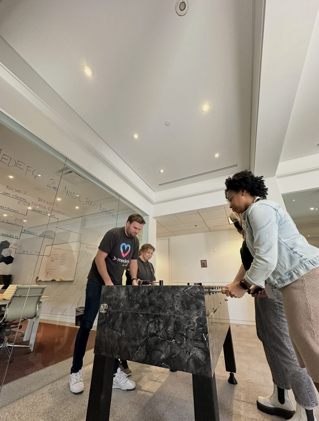 Cameron playing foosball with his team at the office